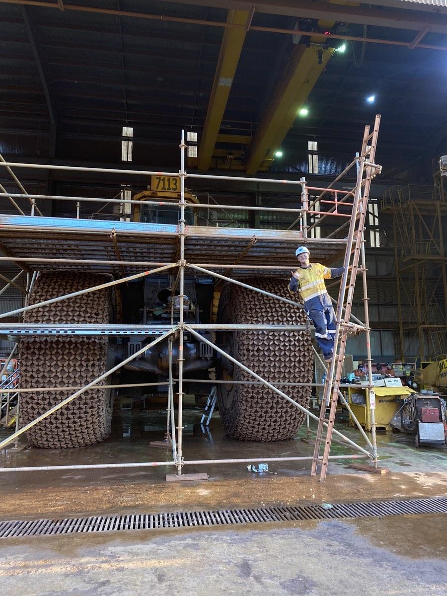 Louis Storath on a ladder at the scaffold around a haul truck