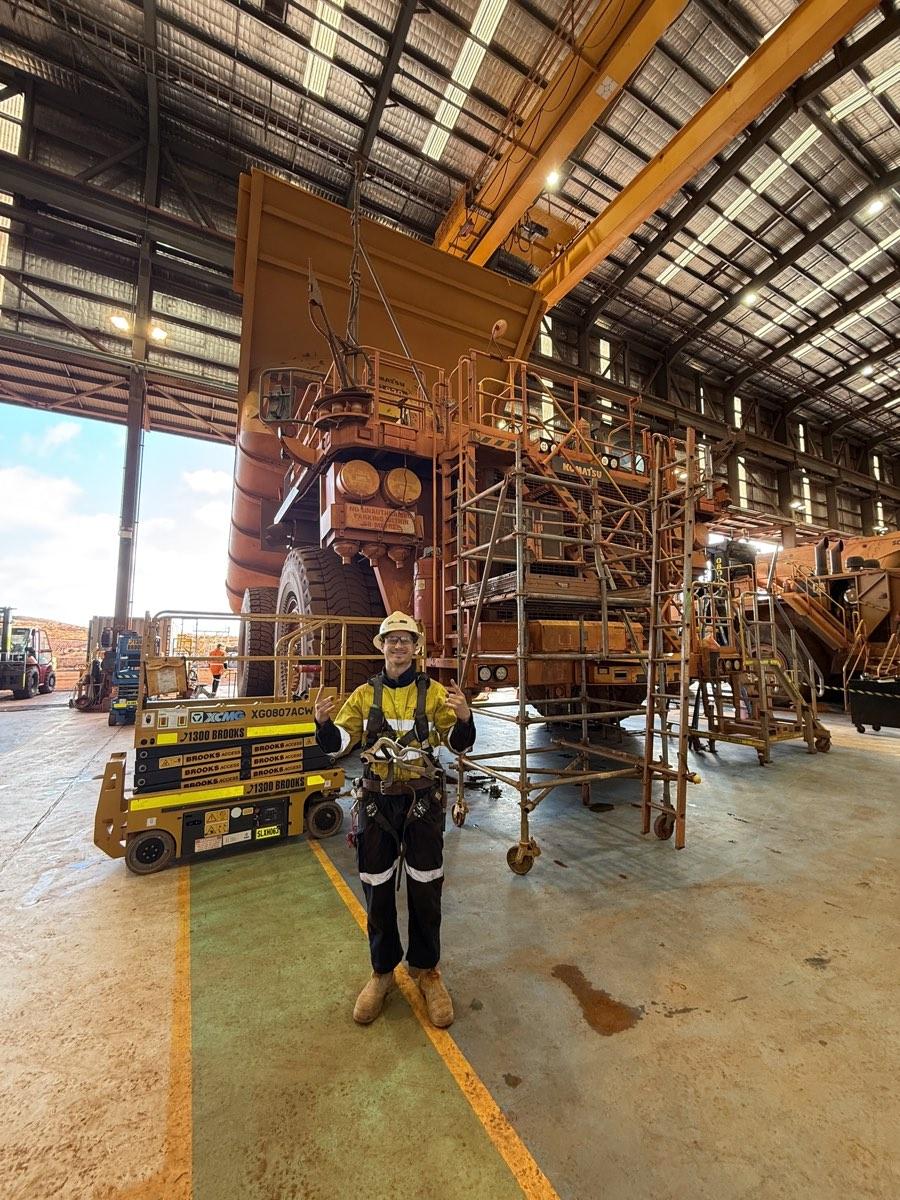 Louis Storath in protective gear in front of a haul truck in the workshop